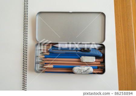 A pencil case containing a pencil for drawing, a tortillon, a rubber band, and a utility knife. A pencil case containing a pencil for drawing, a tortillon, a rubber band, and a utility knife. 86258894