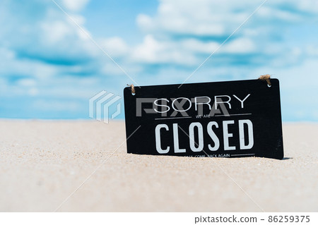 Closed sign on tropical sand beach with blue sky background.  86259375