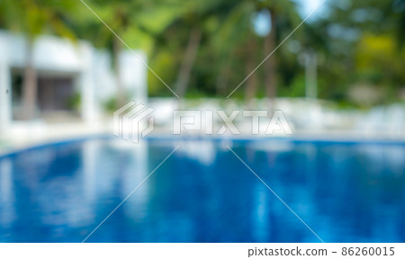 Blurred background of a swimming pool at a resort in the morning with tree. 86260015