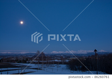 Full moon and snowy mountains in spring Full moon and snowy mountains in spring 86260761