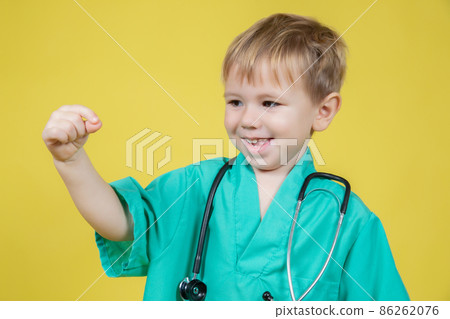 Portrait of little boy dressed in doctors green showing ok gesture 86262076