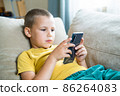 Young boy playing in smartphone. 86264083