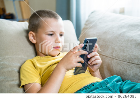 Young boy playing in smartphone. 86264083