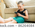 Young boy playing in smartphone. 86264084