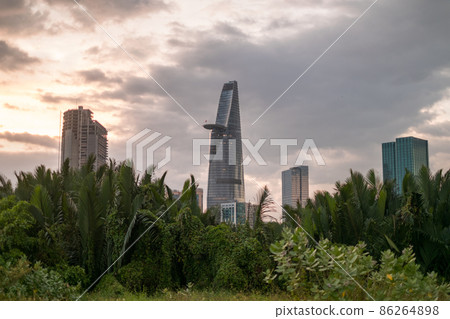 Picture of skyscrapers at sunset in the park with green grass and trees. View in metropolis with modern buildings. High quality photo Picture of skyscrapers at sunset in the park with green grass and trees. View in metropolis with modern buildings. High quality photo 86264898