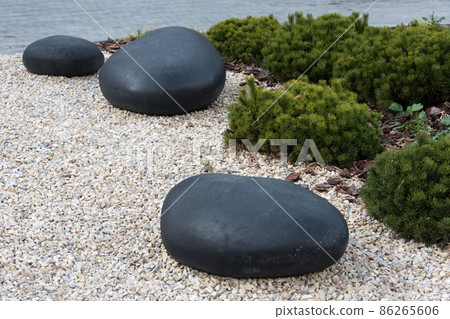 Zen garden dry landscape, or karesansui, japanese rock garden with black stones on white gravel for relaxation and concentration during meditation. Traditional Japanese temple settings Zen garden dry landscape, or karesansui, japanese rock garden with black stones on white gravel for relaxation and concentration during meditation. Traditional Japanese temple settings 86265606
