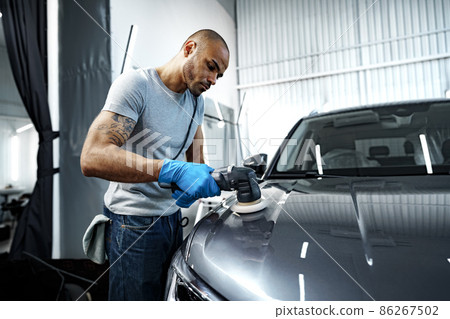 Car detailing. Male hands with orbital polisher in auto repair shop 86267502