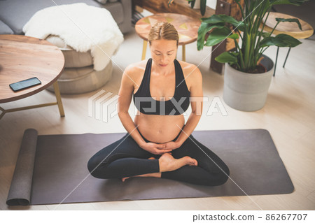 Young beautiful pregnant woman training yoga, caressing her belly. Young happy expectant relaxing, thinking about her baby and enjoying her future life. Motherhood, pregnancy, yoga concept. Young beautiful pregnant woman training yoga, caressing her belly. Young happy expectant relaxing, thinking about her baby and enjoying her future life. Motherhood, pregnancy, yoga concept. 86267707