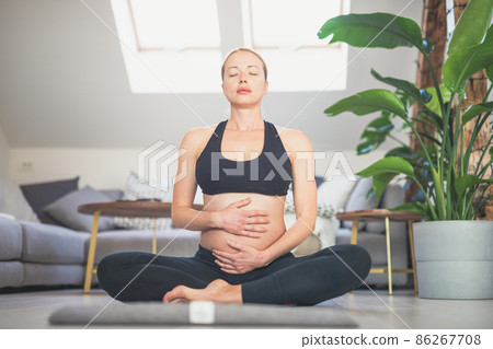 Young beautiful pregnant woman training yoga, caressing her belly. Young happy expectant relaxing, thinking about her baby and enjoying her future life. Motherhood, pregnancy, yoga concept. Young beautiful pregnant woman training yoga, caressing her belly. Young happy expectant relaxing, thinking about her baby and enjoying her future life. Motherhood, pregnancy, yoga concept. 86267708