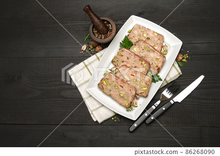 Sliced Traditional French terrine covered with bacon on dark wooden background 86268090