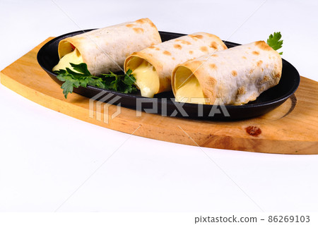 Grilled lavash rolls with suluguni cheese, picnic lunch, appetizer, delicious dish in a frying pan on a white isolated background 86269103