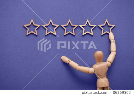 Feedback or rating banner. Wooden men hangs five stars on wall. Top excellent business services rating customer experience concept. New trend in 2022 color Very Peri. 86269503