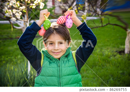 Different color Easter Eggs in a child's hands- egg hunt. 86269755