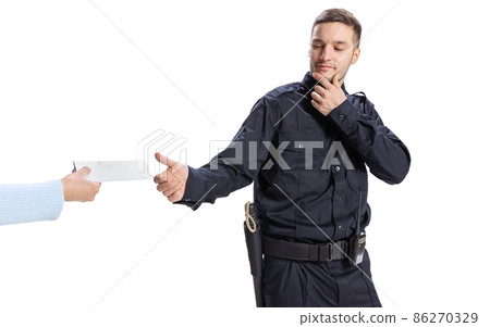 Portrait of young man, policeman wearing black uniform refuses a bribe isolated on white background. Concept of job, caree, law and order. Portrait of young man, policeman wearing black uniform refuses a bribe isolated on white background. Concept of job, caree, law and order. 86270329