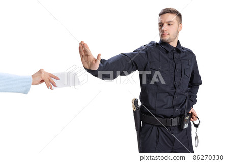 Portrait of young man, policeman wearing black uniform refuses a bribe isolated on white background. Concept of job, caree, law and order. Portrait of young man, policeman wearing black uniform refuses a bribe isolated on white background. Concept of job, caree, law and order. 86270330