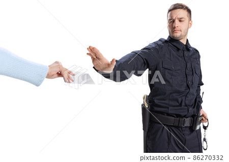 Portrait of young man, policeman wearing black uniform refuses a bribe isolated on white background. Concept of job, caree, law and order. Portrait of young man, policeman wearing black uniform refuses a bribe isolated on white background. Concept of job, caree, law and order. 86270332