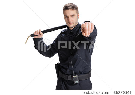 Half-length portrait of young male policeman officer wearing black uniform posing isolated on white background. Concept of job, caree, law and order. Half-length portrait of young male policeman officer wearing black uniform posing isolated on white background. Concept of job, caree, law and order. 86270341
