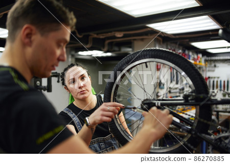 Technicians repairing modern bicycle in garage 86270885