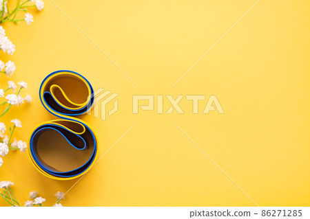 Elastic tape for fitness lies on a yellow background. Eight from a rubber expander for sports. White blumen Elastic tape for fitness lies on a yellow background. Eight from a rubber expander for sports. White blumen 86271285