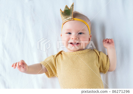 Portrait of happy 4-months-old baby girl lying on the white sheet in bed at home 86271296