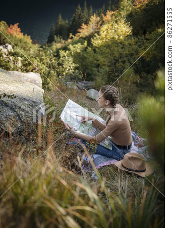 Young woman on a hiking trip sitting on a rock 86271555