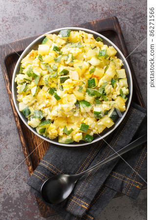 Zarangollo Murciano Stewed Zucchini With Onion and scrambled closeup in the plate. Vertical top view 86271566