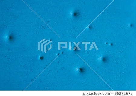 Dents pattern, holes or bullet shot marks on the blue metal surface of the old background iron texture Dents pattern, holes or bullet shot marks on the blue metal surface of the old background iron texture 86271672