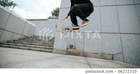 Skateboarder skateboarding outdoors in city Skateboarder skateboarding outdoors in city 86272310