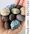 在你手掌上的海灘上撿到的彩色鵝卵石 86273182