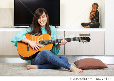 young girl play classic guitar at home young girl play classic guitar at home 86274178