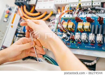 hand of engineer with screwdriver assembles medical equipment after repair hand of engineer with screwdriver assembles medical equipment after repair 86274544