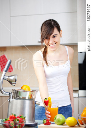 Beautiful woman using juicer for making orange juice Beautiful woman using juicer for making orange juice 86275667