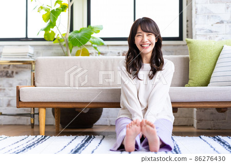 一個年輕的女人在客廳裡放鬆 一個年輕的女人在客廳裡放鬆 86276430