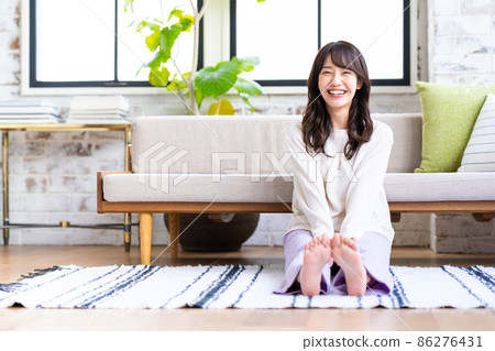 一個年輕的女人在客廳裡放鬆 一個年輕的女人在客廳裡放鬆 86276431