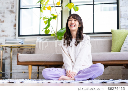 一個年輕的女人在客廳裡放鬆 一個年輕的女人在客廳裡放鬆 86276433