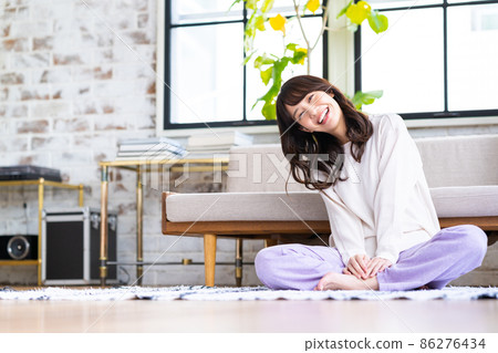 一個年輕的女人在客廳裡放鬆 一個年輕的女人在客廳裡放鬆 86276434