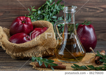 Apple cider vinegar and red apples on a dark, wooden background. Selective focus. fermented product. Healthy food. 86276600