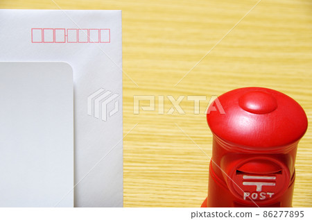 郵箱形狀的存錢罐和放在木桌上的感謝信信封（帶複印空間） 86277895