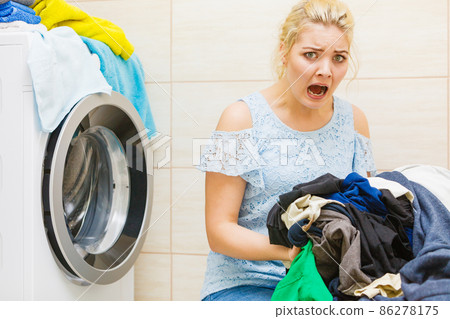 Unhappy girl with dirty clothes laundry. Unhappy girl with dirty clothes laundry. 86278175