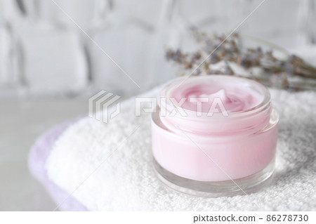 Open jar of cream on towel, closeup. Space for text 86278730
