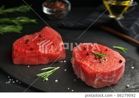 Fresh raw beef cut with spices on black table, closeup 86279092