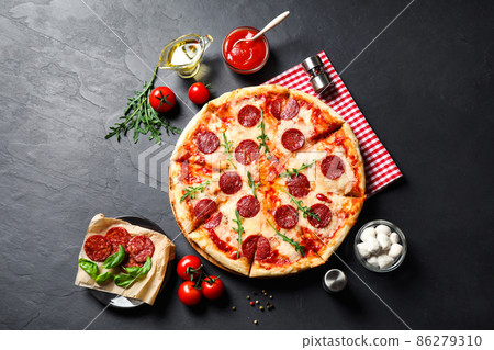 Flat lay composition with hot pepperoni pizza on dark table 86279310