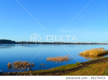 Urban landscape in october with blue sky and autumn trees. 86279410