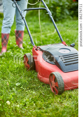 unrecognizable Woman with a lawn mower grass at home garden, gardener woman working unrecognizable Woman with a lawn mower grass at home garden, gardener woman working 86279711
