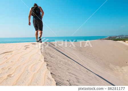 A tourist exploring the white desert dunes in Phan ri Cua, Vietnam A tourist exploring the white desert dunes in Phan ri Cua, Vietnam 86281177