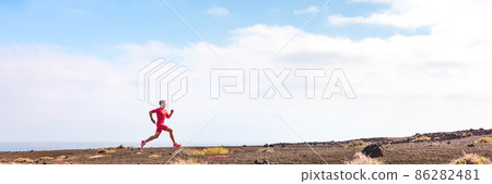 Athlete running man athlete on triathlon run. Hero profile view of runner on hill training hiit workout going uphill. Panoramic landscape crop background 86282481