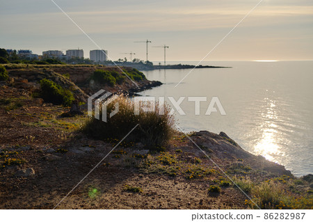Rocky coastline of Punta Prima coastline during sunset Rocky coastline of Punta Prima coastline during sunset 86282987