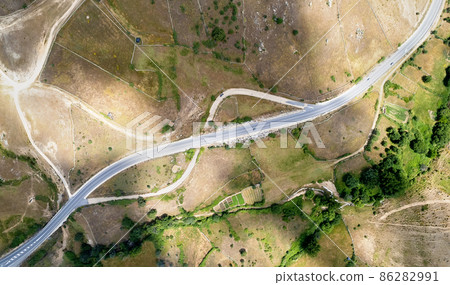 Aerial view highway surrounded by lands and meadows of countryside Aerial view highway surrounded by lands and meadows of countryside 86282991