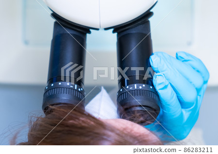 Professional female scientist doing experiment with electronic microscope in scientific genetic research laboratory Professional female scientist doing experiment with electronic microscope in scientific genetic research laboratory 86283211