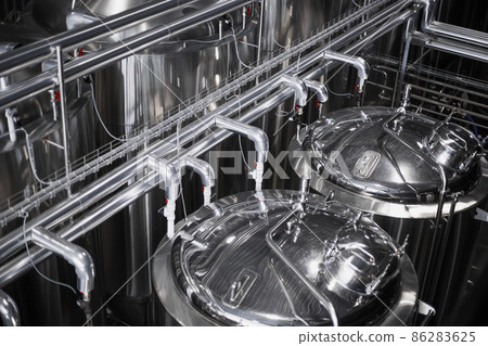 Modern Beer Factory. Steel tanks for beer fermentation and storage. Brewery. Modern beer plant with brewering kettles Modern Beer Factory. Steel tanks for beer fermentation and storage. Brewery. Modern beer plant with brewering kettles 86283625